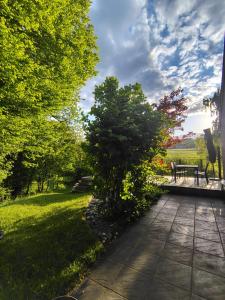 a park with a bench and a tree and grass at La clé des champs chambre d'hôtes in Theux +5 photos