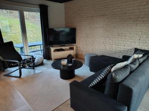 a living room with a couch and a television at La clé des champs chambre d'hôtes in Theux