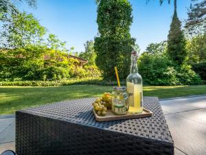 a bottle of wine and a plate of grapes on a table at Holiday Home Gustine - 300m from the sea by Interhome in Egå