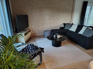 a living room with a couch and a table at La clé des champs chambre d'hôtes in Theux