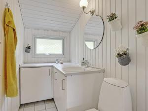a bathroom with a sink and a mirror and a toilet at Holiday Home Elpida - 100m from the sea by Interhome in Glesborg +29 photos