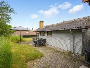 a patio with a table and an umbrella at Holiday Home Elpida - 100m from the sea by Interhome in Glesborg