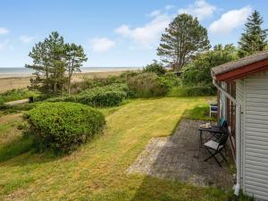 a view of the backyard of a house with a table next to a shed at Holiday Home Elpida - 100m from the sea by Interhome in Glesborg