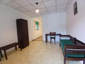 a room with a bed and a table and chairs at Villa Coleus in Tangalle