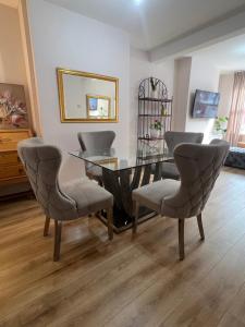 a dining room with a glass table and chairs at Liverpool Rose House Stylish 3 Bed Near Anfield and Goodison Park in Liverpool