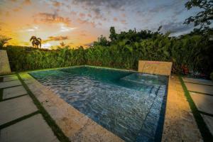 a swimming pool with a sunset in the background at Villa Dulce Refugio in Cabrera