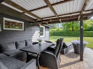 a patio with a table and chairs under a pergola at Holiday Home Sunja - 450m from the sea by Interhome in Brøndstrup +17 photos