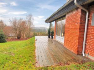 una terraza de madera junto a un edificio de ladrillo en Holiday Home Gerret by Interhome, en Bryrup