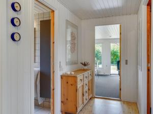 a bathroom with a wooden dresser and a mirror at Holiday Home Hila - 900m from the sea by Interhome in Knebel +17 photos