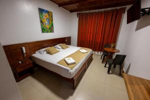 ein Schlafzimmer mit einem Bett und einem Tisch darin in der Unterkunft Hostal Macambo in Iquitos + 21 Fotos