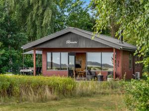 a small cabin with a glass door on a field at Holiday Home Tayana - 75m to the inlet by Interhome in Storvorde