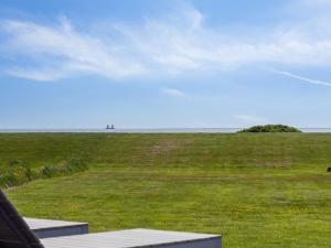a view of a field of grass with a tree in the distance at Holiday Home Gundborg - 100m from the sea by Interhome in Storvorde