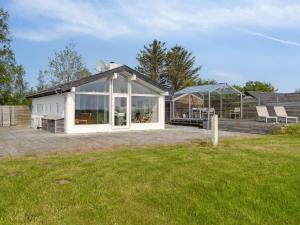 a large white house with a glass roof at Holiday Home Gundborg - 100m from the sea by Interhome in Storvorde