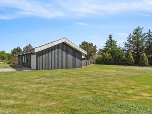 a house with a grassy yard in front of a building at Holiday Home Ljupco - 500m to the inlet by Interhome in Storvorde