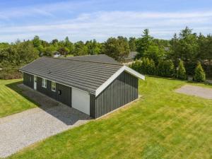 a black and white building on a grass field at Holiday Home Ljupco - 500m to the inlet by Interhome in Storvorde