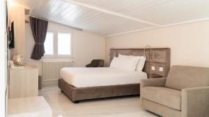 a bedroom with a bed and a couch and a chair at Principe Boemondo Luxury Room in Canosa di Puglia