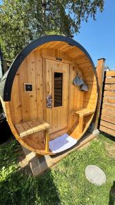 a large wooden sauna with a bench in the grass at Cowichan Valley Retreat with Sauna & Free EV Charger in Duncan