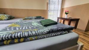 a bed in a bedroom with a table and flowers at Agroturystyka Klekusiowo in Bolesławiec
