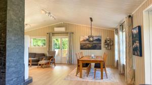 a dining room and living room with a table and chairs at Leilighet med flott uteplass in Ulefoss