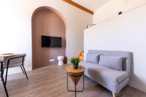 un salon avec un canapé et une table dans l'établissement L'Ile Barbe - Studio cosy avec mezzanine, à Caluire-et-Cuire