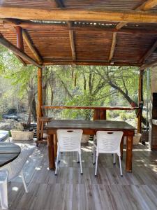 a wooden table and chairs on a wooden deck at Ohana Apartments (solo familias) in Villa Carlos Paz