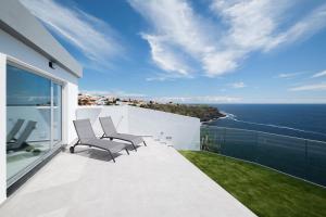 a balcony with chairs and a view of the ocean at Beira Da Rocha in Ponta Delgada