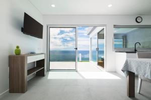 a white kitchen with a view of the ocean at Beira Da Rocha in Ponta Delgada