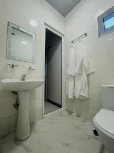 a white bathroom with a sink and a toilet at Tsikhisdziri Panorama Cottage in K'obulet'i