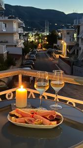 a table with two glasses of wine and a plate of food at Elina's Rooms in Poros +15 photos