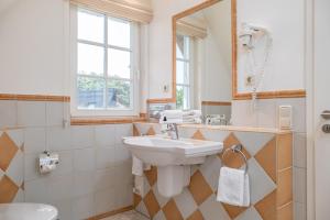 un bagno con lavandino e specchio di Dünentraum a Neuhaus Altre 24 foto