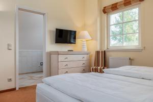 una camera da letto con un letto e una TV a parete di Dünentraum a Neuhaus