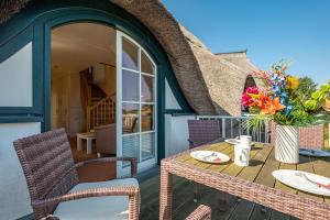 un patio con tavolo e sedie in una casa di Dünentraum a Neuhaus