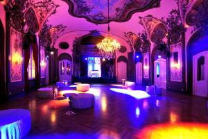 a room with pink and purple lighting and tables in it at Hotel Deutsches Theater Landwehrstraße in Munich