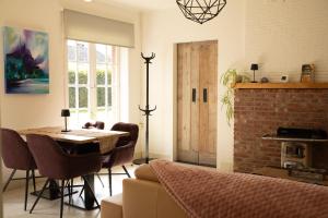 a dining room with a table and a brick wall at Tussen Heide en Bos, unwind in nature in Opglabbeek