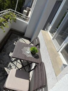 einen Tisch und Stühle auf einem Balkon mit einer Pflanze in der Unterkunft В къщи in Weliko Tarnowo