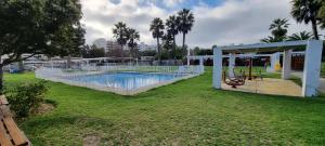 a swimming pool in a yard with a playground at Avenida del Mar Condominio Oceanic in La Serena