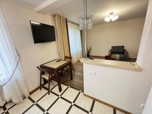 a small living room with a table and a television at квартира поруч з парком in Umanʼ