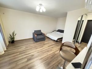 a bedroom with a bed and a chair in a room at квартира поруч з парком in Umanʼ