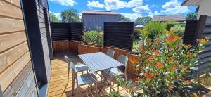 a patio with a table and chairs and flowers at Appartement cosy 