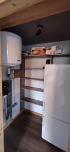 a small kitchen with white cabinets and a refrigerator at Appartement cosy  +1 photo