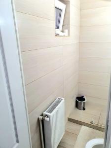 a small bathroom with a radiator and a sink at Relax Apartament Bicaz in Bicaz