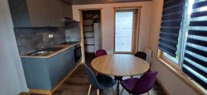 a small kitchen with a table and purple chairs at Appartement cosy 