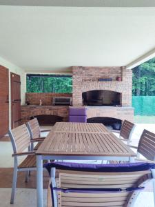 a patio with a table and chairs and a fireplace at Villa Kamenica in Zavidovići