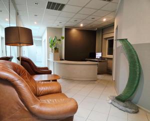 a waiting room with a leather chair and a green sculpture at Lipowa Guest House in Bielawa