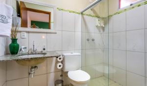 a bathroom with a toilet and a sink and a shower at Pousada Container Eco Manguinhos in Manguinhos