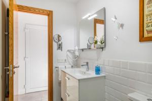 a white bathroom with a sink and a mirror at Tranquilidad entre volcanes in Uga +19 photos