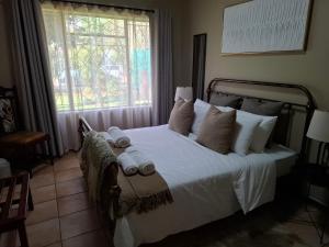 a bedroom with a large bed with towels on it at Just Dandee in Naboomspruit