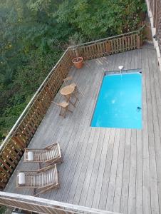 ラ・ロック・ガジャックにあるle petit bambouのデッキ(スイミングプール、椅子2脚、テーブル付)