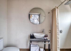 un baño con lavabo y espejo en Casa Umbral Glampings, en Ciudad de México