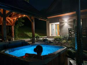 a woman sitting in a hot tub in a backyard at Dwie Owce in Istebna